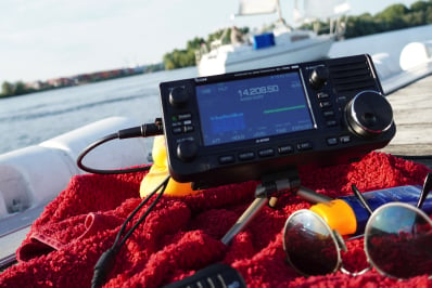 radio on beachtowel and sailing boat in the background